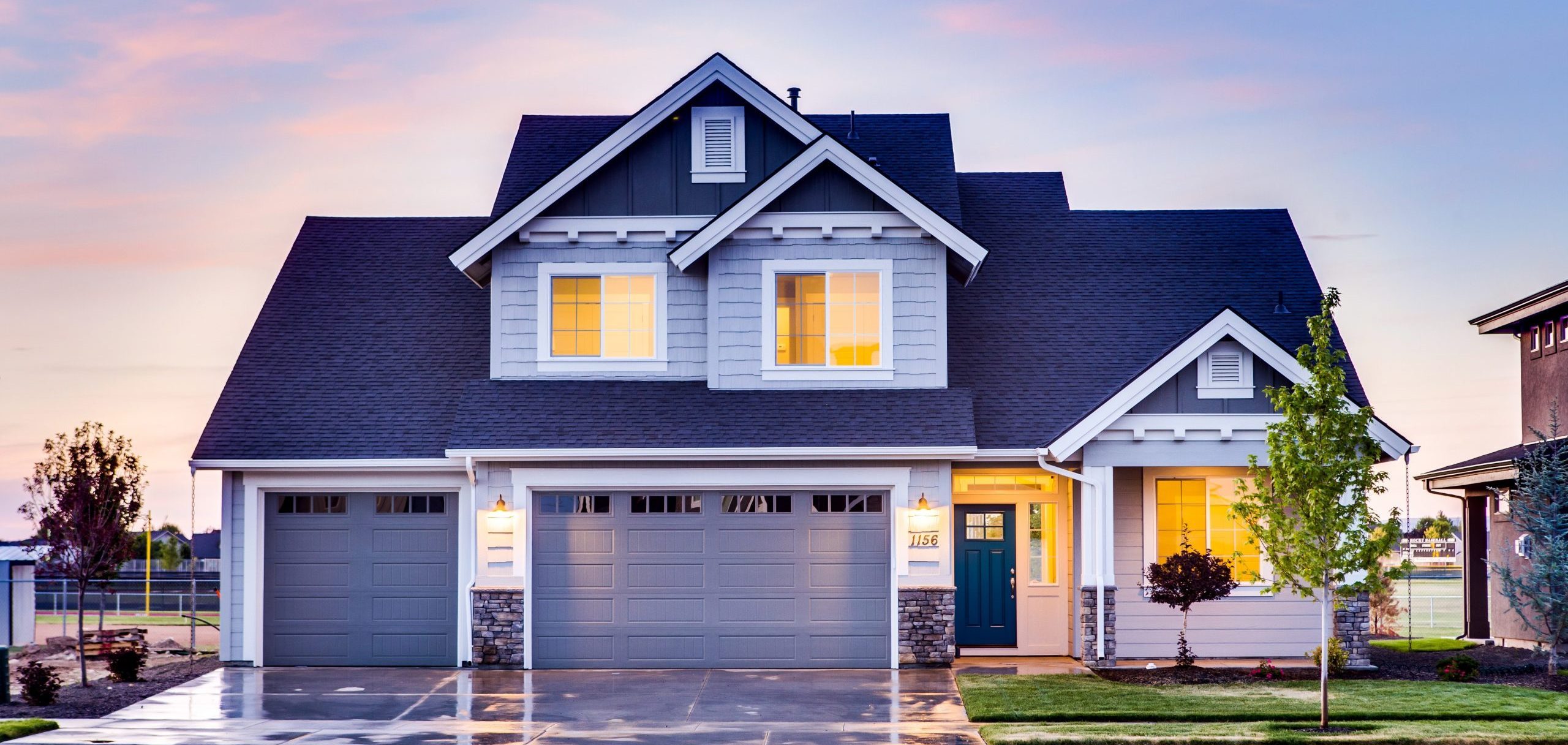 Modernes Einfamilienhaus in der Abenddämmerung mit beleuchteten Fenstern – Symbolbild für Immobilienbewertung, Wertermittlung und professionelle Einschätzung des Immobilienwerts.